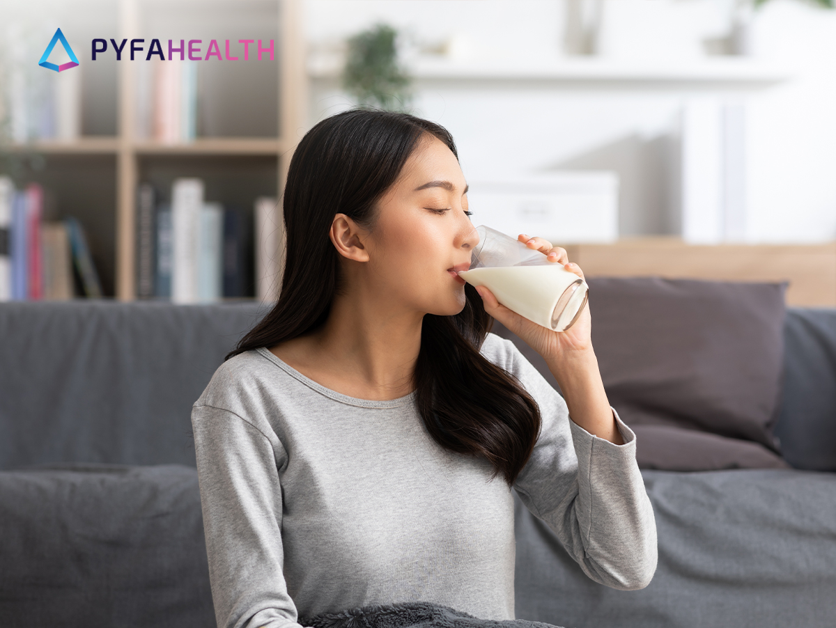 perempuan duduk minum susu penambah berat badan untuk dewasa